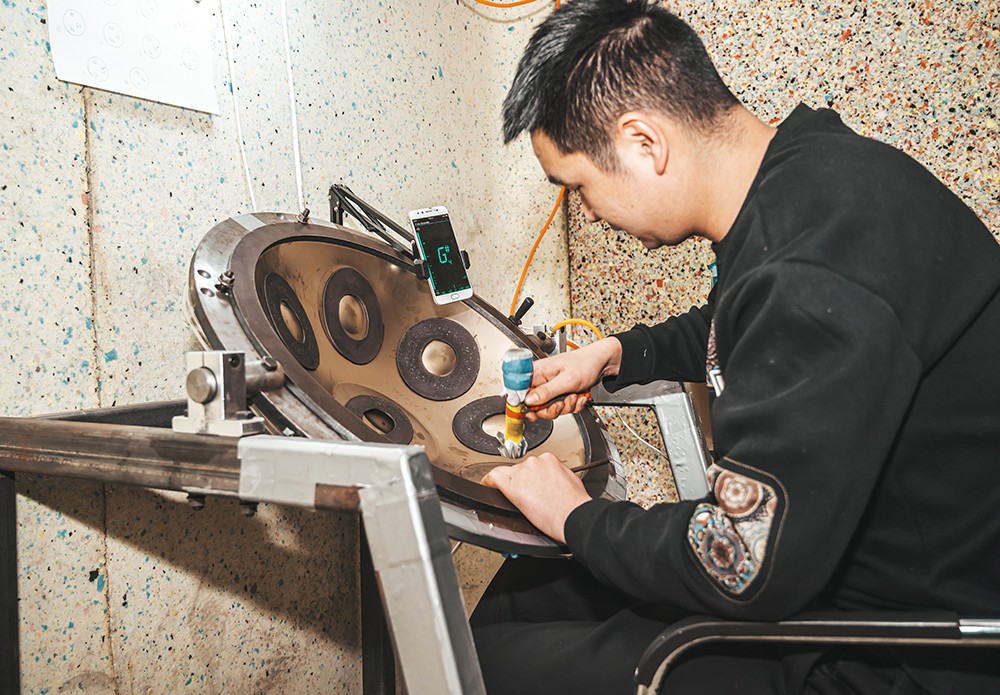 Craftsperson tuning a handpan